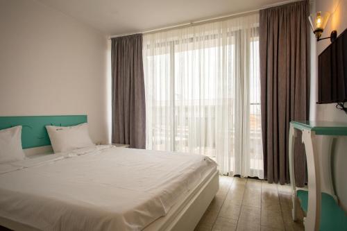 a bedroom with a large bed and a large window at The Moon Vama Veche in Vama Veche