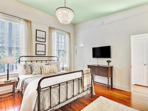 een slaapkamer met een bed en een flatscreen-tv bij Gordon Inn Tree Top in Savannah