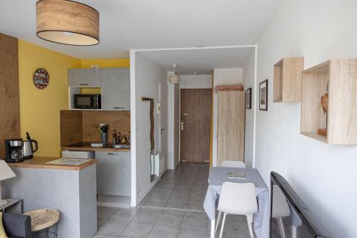 une petite cuisine avec une table et des chaises dans une pièce dans l'établissement ~Joli studio à 100 m de la plage, à Les Sables-dʼOlonne