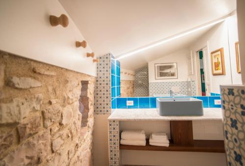 a bathroom with a sink and a stone wall at La Viola di Assisi in Assisi
