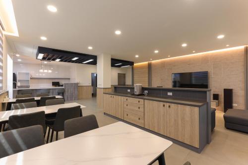 a restaurant with tables and chairs and a kitchen at Yonezawa Guest House in Magong