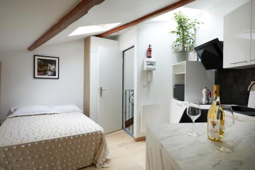 une chambre avec un lit et des verres à vin sur un comptoir dans l'établissement Art Lovers Apart Third Floor, à Béziers