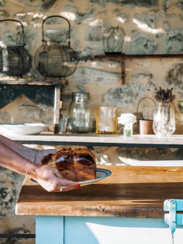 a person holding a plate with a loaf of bread at Le Molina B&B in Massa e Cozzile