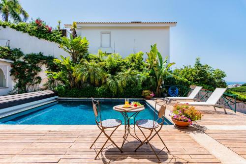 a patio with a table and chairs next to a pool at Estoril Riviera Apartments in Estoril