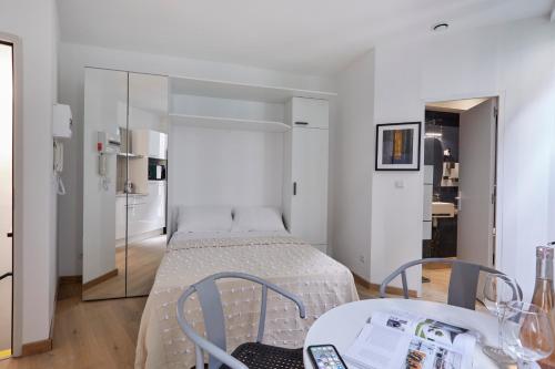 une chambre avec un lit, une table et des chaises dans l'établissement Art Lovers Apart Floor 2, à Béziers