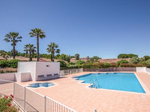 una gran piscina en un patio con palmeras en Green village, en Roquebrune-sur-Argens