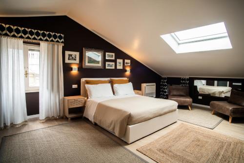 ein Schlafzimmer mit einem großen Bett und einem Dachfenster in der Unterkunft La Viola di Assisi in Assisi