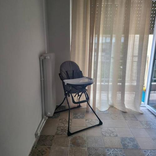 a chair sitting in a room with a window at Μοντέρνο διαμέρισμα στη Βέροια (LIBERTY) in Veria