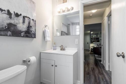 a white bathroom with a sink and a mirror at Maple Heights Retreat in Maple Heights