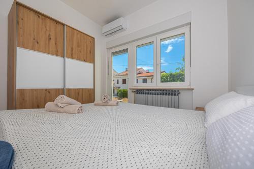 sypialnia z dużym łóżkiem z dwoma ręcznikami w obiekcie Happy Holiday w mieście Dramalj