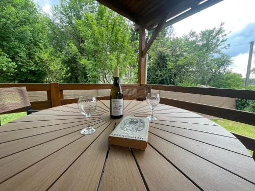 - une bouteille de vin et deux verres sur une table en bois dans l'établissement Mura Völgye Vendégház, à Murarátka
