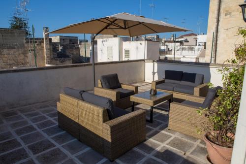 patio con sedie e ombrellone sul tetto di GoodStay Central Suite -Terrace & Charme- a Lecce