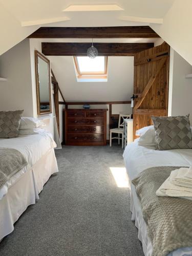 a bedroom with two beds and a dining room at Ivy Cottage in Launceston