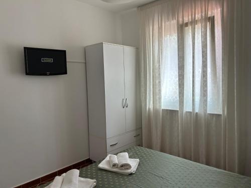 1 dormitorio con 1 cama, armario y toallas en La Veduta, en Praia a Mare