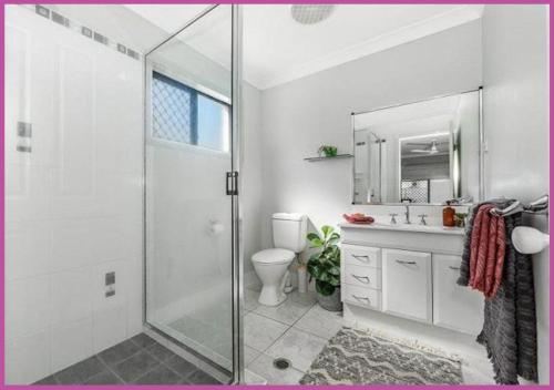 a bathroom with a shower and a toilet and a sink at Sarina Court 8 in Ross River