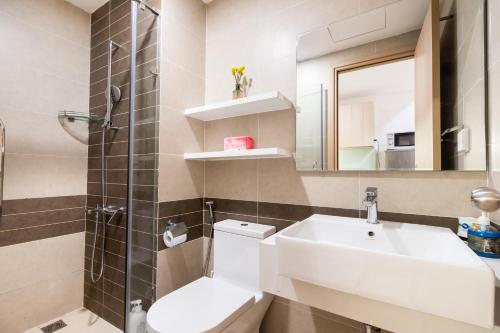 ein Badezimmer mit einem Waschbecken, einem WC und einem Spiegel in der Unterkunft Awesome Tracy's Apartment in Ho-Chi-Minh-Stadt