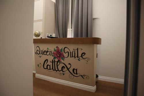 熱那亞的住宿－Queen Cattleya Suite，一种标志,上面写着一个房间的女王旁廊