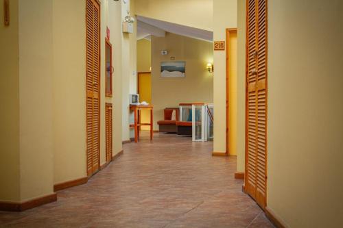 a hallway with doors and a room with a table at Hotel Departamentos del Sur in Puerto Montt