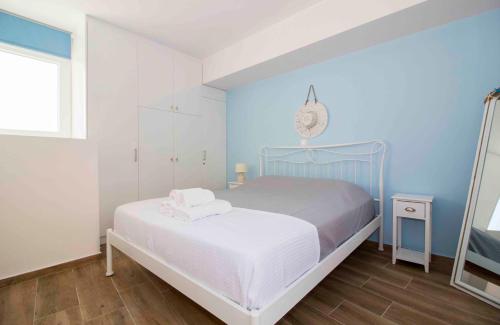 um quarto com uma cama e uma parede azul em Laconian Collection Cosy House in the heart of Gytheio em Gytheio