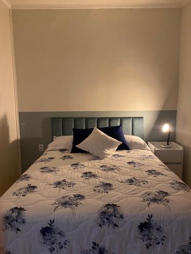 um quarto com uma cama com um edredão azul e branco em Casa Vita BG - Casa de campo em Bento Gonçalves