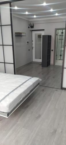 1 dormitorio con 1 cama en una habitación con espejo en Стильная, уютная квартира для отдыха № 53, en Almaty