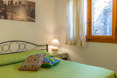 ein Schlafzimmer mit einem grünen Bett und einem Fenster in der Unterkunft Casa Ginepro in Olbia