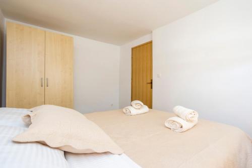 a bedroom with two beds with towels on them at Apartment Martina in Vantačići