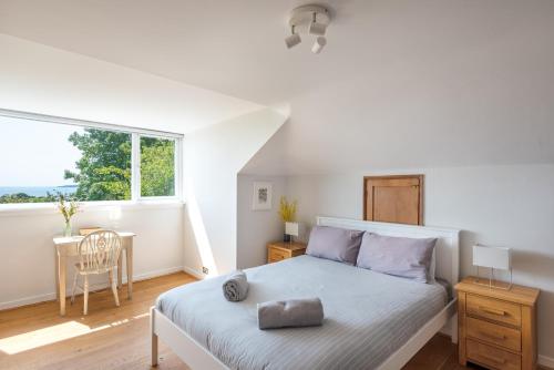 - une chambre avec un lit, une table et une fenêtre dans l'établissement Manacles - Spacious flat near beach with sea views & parking, à Falmouth