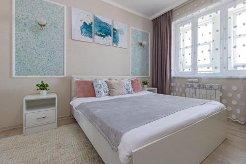een slaapkamer met een groot bed en een raam bij Евродвушка в ЖК Orynbor Towers in Astana