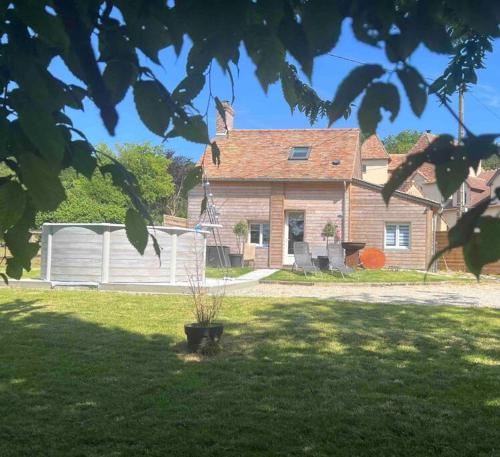 a house with a yard with a garage at Cottage cocooning romantique avec jaccuzzi privé in Ancinnes