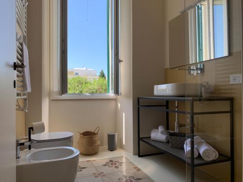 ein Bad mit einer Badewanne, einem Waschbecken und einem Fenster in der Unterkunft Il Sogno di Mimì in Polignano a Mare
