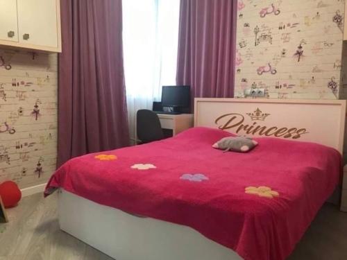 1 dormitorio con 1 cama con edredón rojo en Sweet house en Batumi