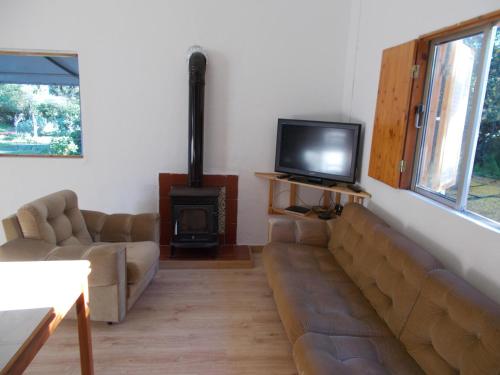 a living room with a couch and a tv and a stove at Casa Fonte in Santo Estêvão