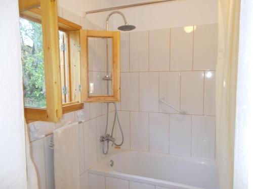 ein Bad mit einer Badewanne und einem Fenster in der Unterkunft Casa Fonte in Santo Estêvão