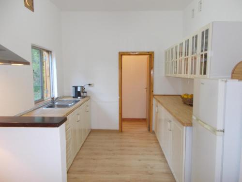 a kitchen with white cabinets and a sink at Casa Fonte in Santo Estêvão