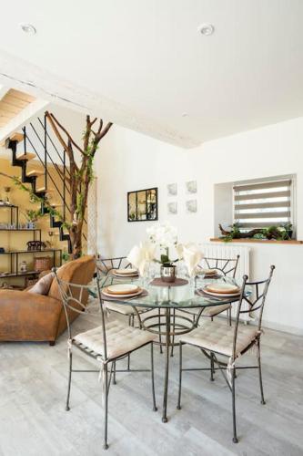 une salle à manger avec une table et des chaises en verre dans l'établissement Relaxing cottage bain nordique, à Ancinnes