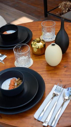 a wooden table with black plates of food and silverware at Eterna Tulum in Tulum