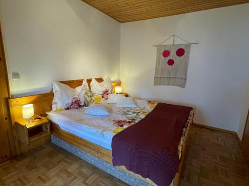 Latschach ober dem FaakerseeにあるApartments Wrolichのベッドルーム1室(花の咲く大型ベッド1台付)