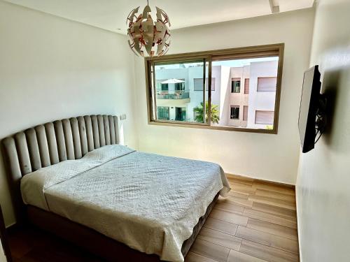 a bedroom with a bed and a window at Blue Beach, Sidi Rahal, Appartement pour familles in Sidi Rahal