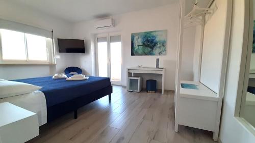 um quarto com uma cama azul e uma televisão em Maison Margherita em Santa Teresa Gallura