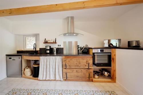 - une cuisine avec un comptoir, un évier et une cuisinière dans l'établissement La Mélézière-Ecrin Appartement 4 étoiles 120m2 6 personnes plein sud, aux Orres