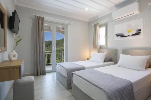 a hotel room with two beds and a balcony at Panoutsis Villa - Sivros Lefkada in Sívros