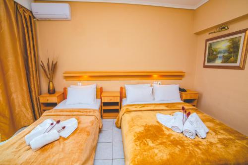 a hotel room with two beds with towels on them at THEMIS BEACH in Paralia Katerinis