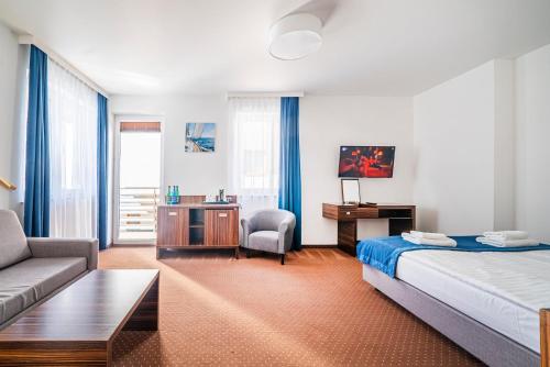 ブワディスワボボにあるMarina Apartamenty & Pokojeのベッドとソファ付きのホテルルーム