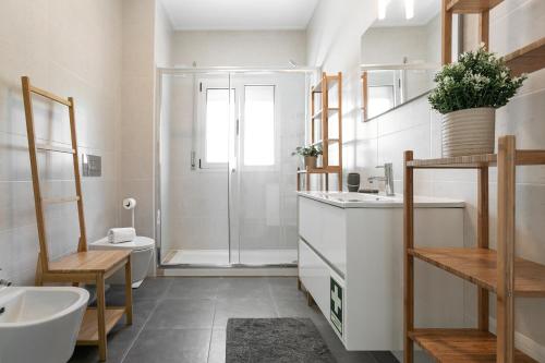 a bathroom with a shower and a sink and a toilet at Nazaré Seashell House in Nazaré