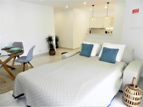een witte slaapkamer met een bed en een tafel bij Carvoeiro Boutique Apartment in Carvoeiro