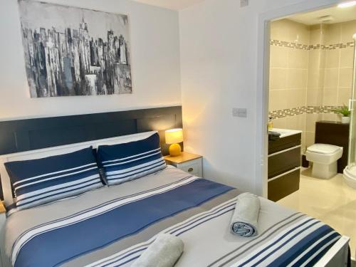 a bed with blue and white pillows in a bedroom at Apartment 3 Benllech with Sea views in Benllech