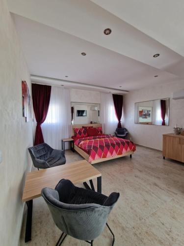 sypialnia z łóżkiem i krzesłami w pokoju w obiekcie Rooms Green Set w Belgradzie