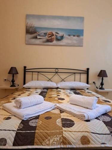 a bedroom with a bed with towels on it at Corfu Town Cozy Apartment in Ágios Rókkos