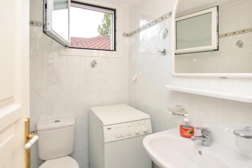 a white bathroom with a toilet and a sink at Kefalonia, Lixouri family friendly house & parking in Lixouri